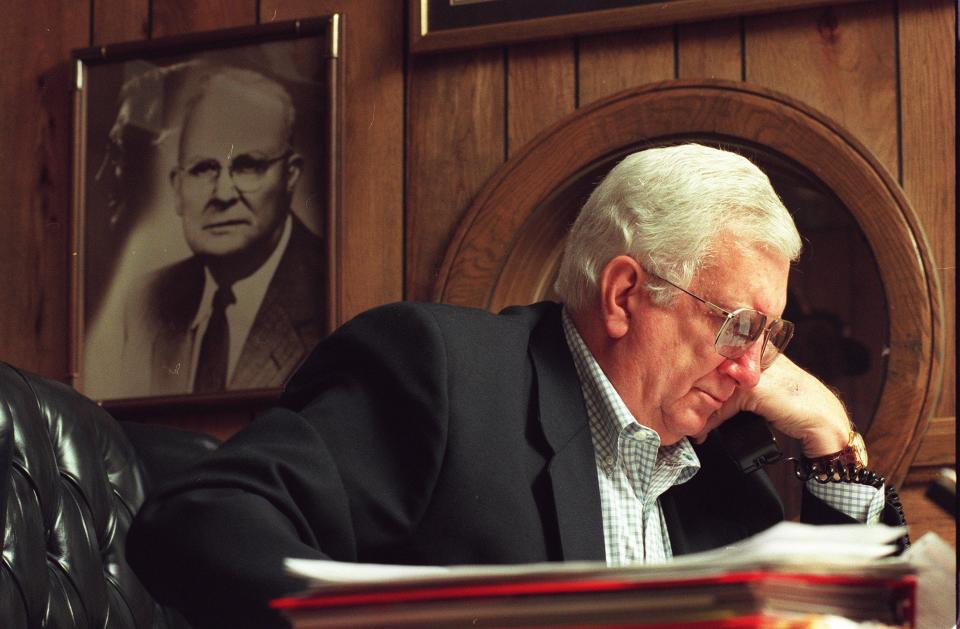 J.P. Hall Jr. handles some business in his First Union Bank office in Green Cove Springs in 1998 with a picture of his father, J.P. Hall Sr., in the background.