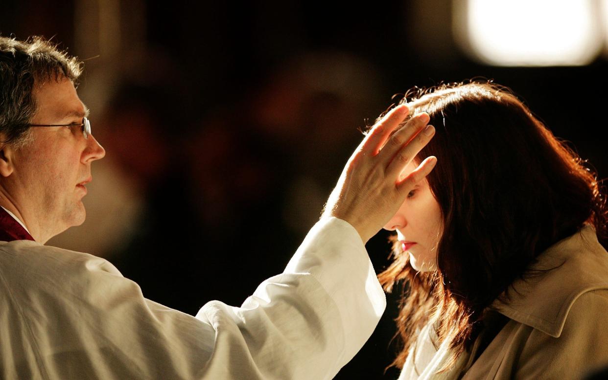 A churchgoer receives a cross of ashes painted on her forehead from a priest during Ash Wednesday Mass at Westminster Cathedral - Peter Macdiarmid/Getty Images