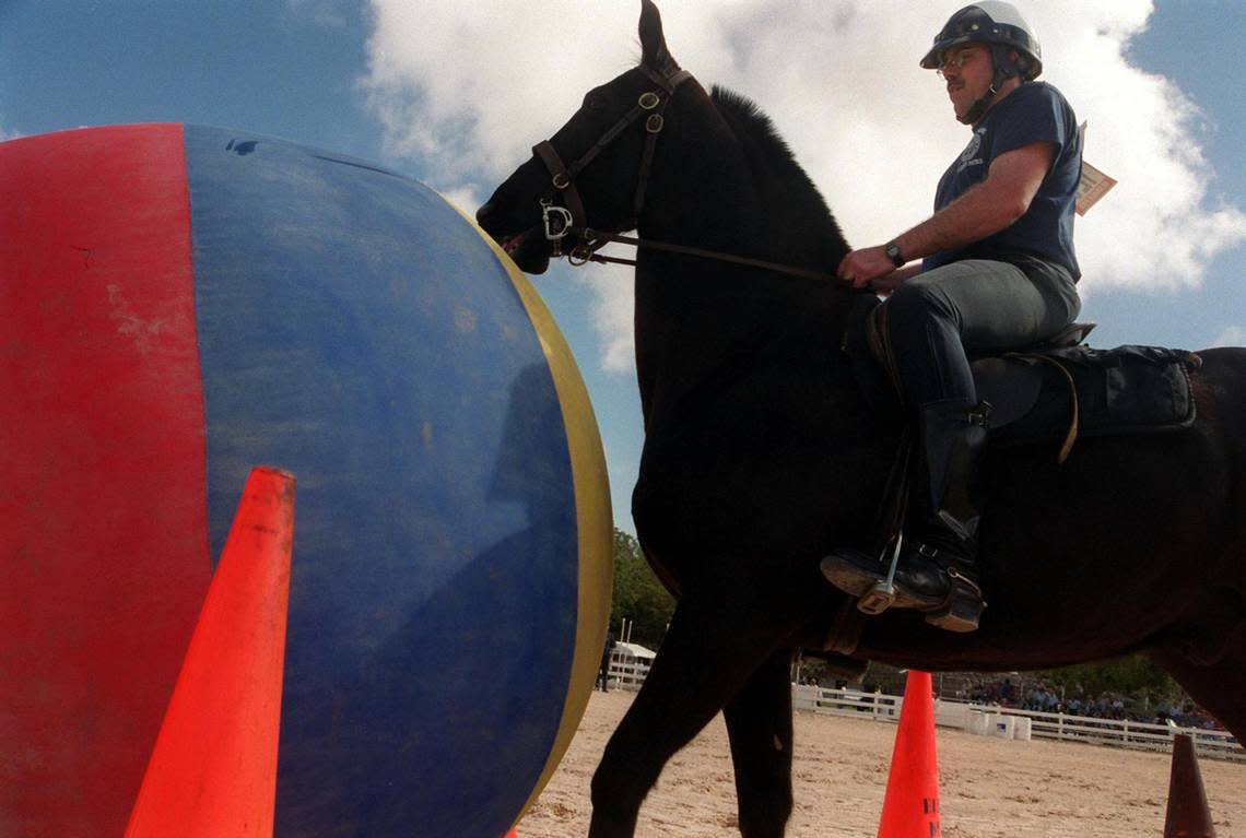 Fort Lauderdale officer Bill Sarantis guides his horse Ebony through a crowd control exercise at the Domino Tournament Fundraiser for the Disabled.