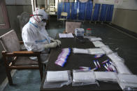 A health worker arranges swab samples of people to test for COVID-19 at a government hospital in Jammu, India, Thursday, Oct.29, 2020. India's confirmed coronavirus caseload surpassed 8 million on Thursday with daily infections dipping to the lowest level this week, as concerns grew over a major Hindu festival season and winter setting in. (AP Photo/Channi Anand)