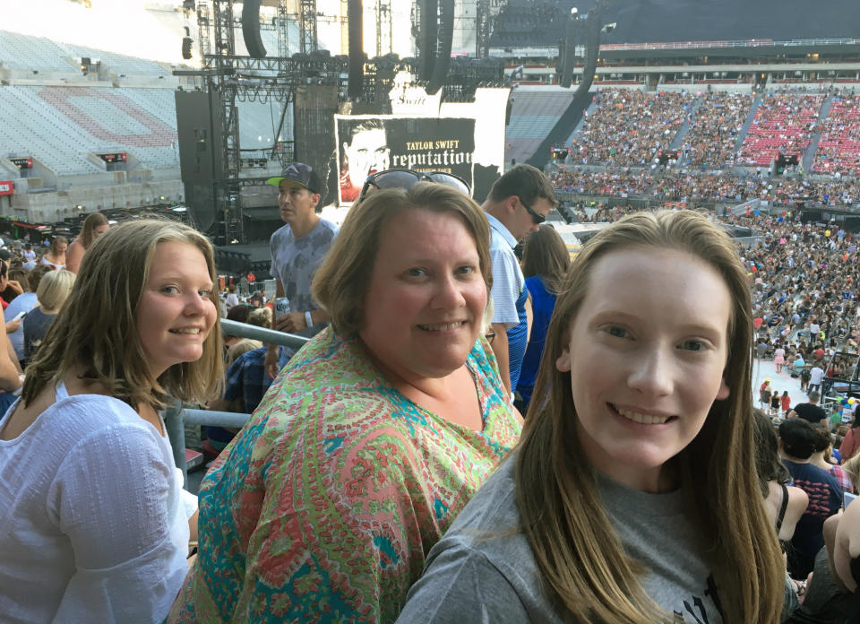 This photo shows Natasha Mitchner, center, at a Taylor Swift concert in Columbus, Ohio, on July 7, 2018, with her now 17-year-old daughter, Melisse Bretz, left, and her now 20-year-old daughter, Amea Bretz. Mitchner scored tickets to a Taylor Swift concert during her tour next year after several hours in the Ticketmaster queue. (Natasha Mitchner via AP)