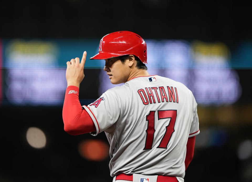 Los Angeles Angels designated hitter Shohei Ohtani gestures after reaching third base on a throwing error by Seattle Mariners' J.P. Crawford during the sixth inning of a baseball game Tuesday, April 4, 2023, in Seattle. (AP Photo/Lindsey Wasson)