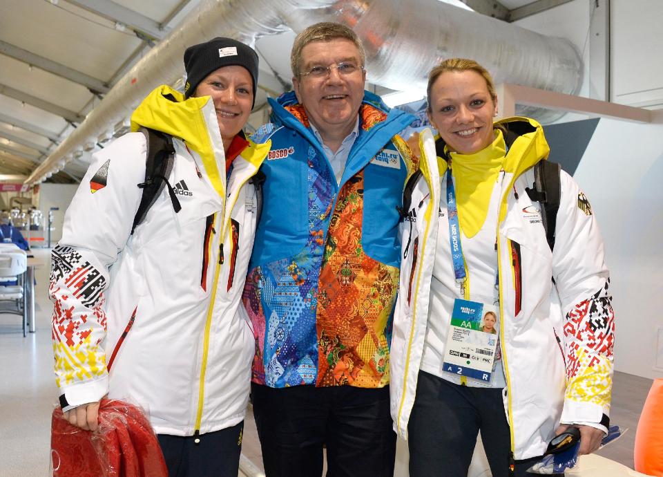 IOC President Thomas Bach poses with German Ice Hockey players Franziska Busch, left, and Susann Goetz as he visits the Athletes Olympic Village prior to the 2014 Winter Olympics on Saturday, Feb. 1, 2014 in Sochi, Russia. The games run from Feb. 7-23. (AP Photo/Pascal Le Segretain, Pool)