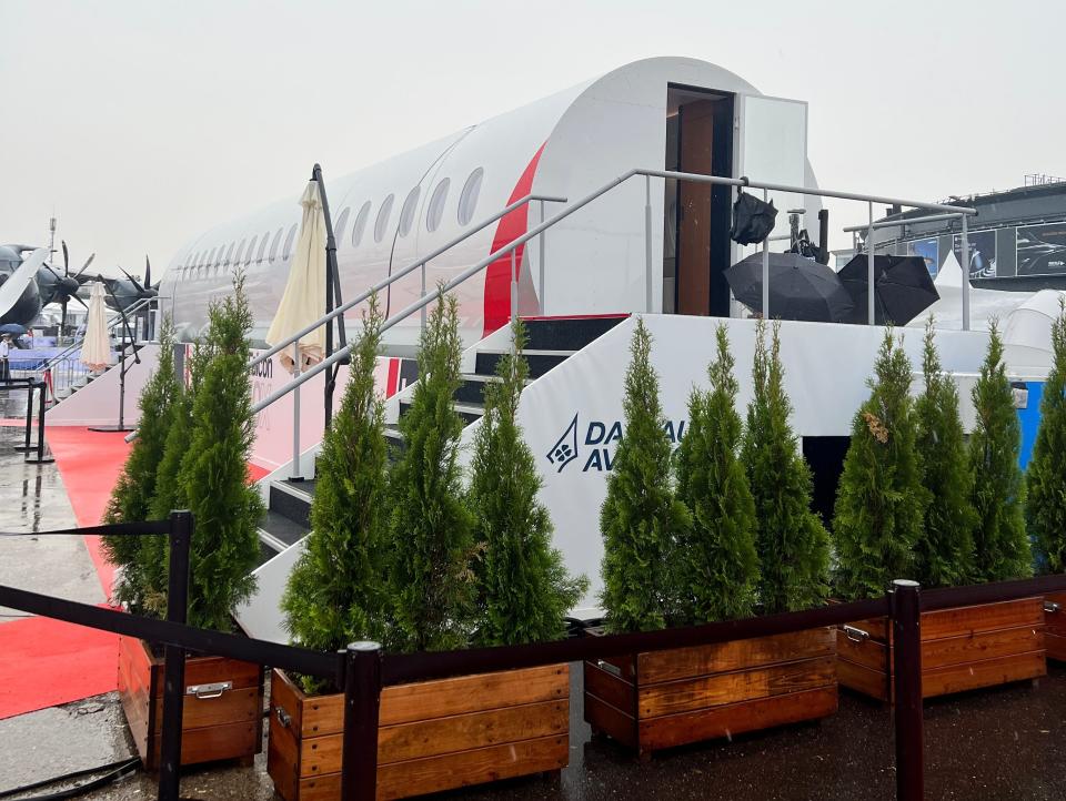 The rear exit to a Falcon 10X mockup cabin, with a staircase, red carpet, and small decorative trees.