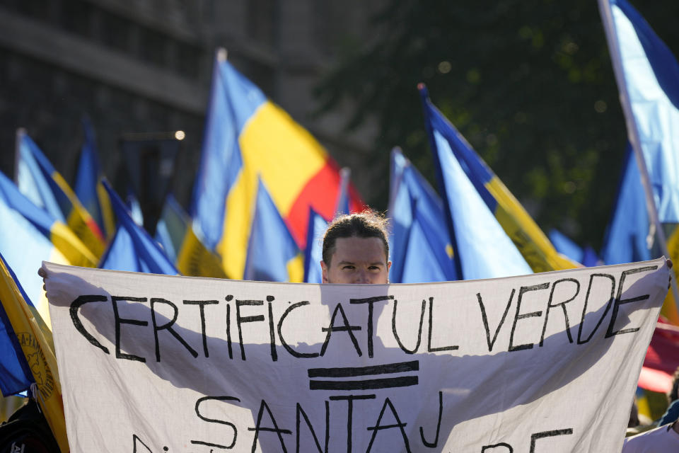 A man holds a banner that reads "Green certificate = Blackmail" as he takes part in an anti-government protest organised by the far-right Alliance for the Unity of Romanians or AUR, in Bucharest, Romania, Saturday, Oct. 2, 2021. Thousands took to the streets calling for the government's resignation, as Romania reported 12,590 new COVID-19 infections in the past 24 hour interval, the highest ever daily number since the start of the pandemic. (AP Photo/Vadim Ghirda)