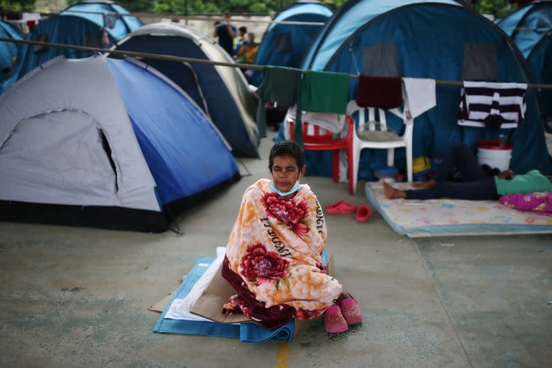 A Venezuelan migrant rests on a pillow inside a coliseum where a temporary camp has been set up, after fleeing her country due to military operations, according to the Colombian migration agency, in Arauquita