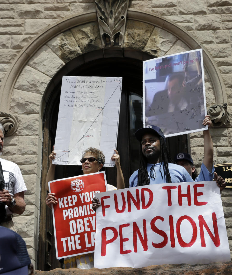 FILE - In this Tuesday, May 12, 2015 file photo, protesters hold signs as they gather in front of the Statehouse in Trenton, N.J. In a report released on Tuesday, Sept. 14, 2021, the Pew Charitable Trust found that the four states with the most endangered pension systems — Illinois, Kentucky, New Jersey and Pennsylvania — have been ramping up contributions even faster, averaging annual growth of 16%. (AP Photo/Mel Evans, File)