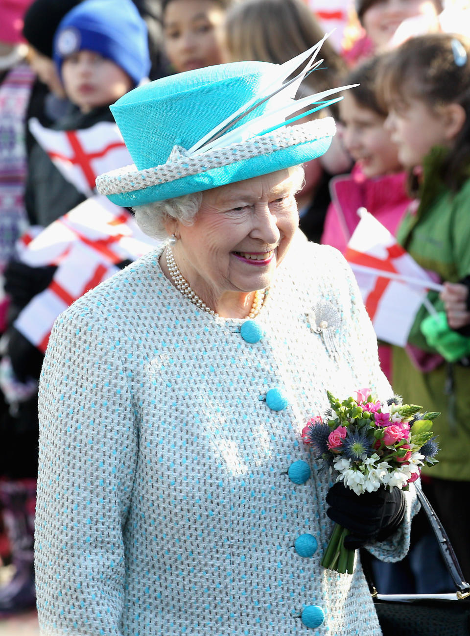 KING'S LYNN, ENGLAND - FEBRUARY 06: Queen Elizabeth II smiles as children wave flags during a visit to Dersingham School on February 6, 2012 in King's Lynn, England. The Queen made the visit to the school as she celebrates Accession Day and 60 years on the throne. (Photo by Chris Jackson/Getty Images)