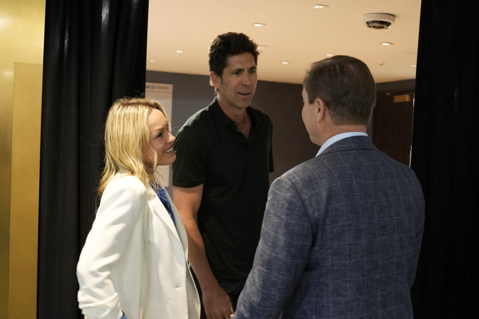 Golden State Warriors president and general manager Bob Myers, center, talks with owner Joe Lacob, right, as his wife Kristen Myers looks after an NBA basketball news conference in San Francisco, Tuesday, May 30, 2023. Myers is departing the Warriors after building a championship team that captured four titles in an eight-year span. One of the most successful GMs over the past decade in any sport, Myers' contract was set to expire in late June. (AP Photo/Eric Risberg)