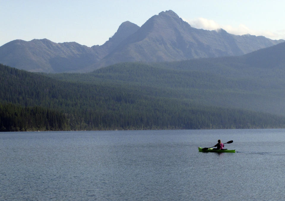 This Sept. 6, 2013, photo shows Ingrid Forsmark kayaking on Kintla Lake in Glacier National Park, Mont. Forsmark says she returns to the remote lake near the Canadian border because of its manager, Lyle Ruterbories. He is the National Park Service's oldest ranger at age 93. (AP Photo/Matt Volz)