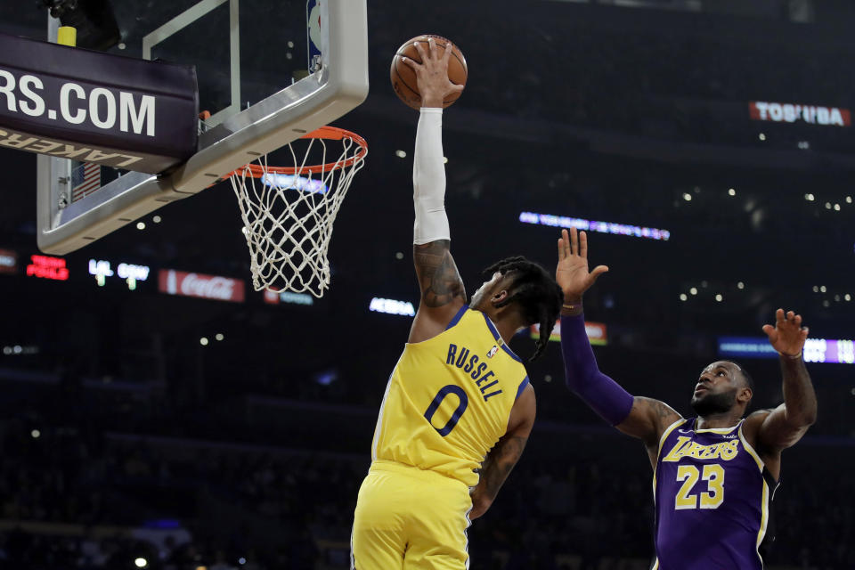 Golden State Warriors' D'Angelo Russell (0) dunks past Los Angeles Lakers' LeBron James (23) during the first half of an NBA basketball game Wednesday, Nov. 13, 2019, in Los Angeles. (AP Photo/Marcio Jose Sanchez)