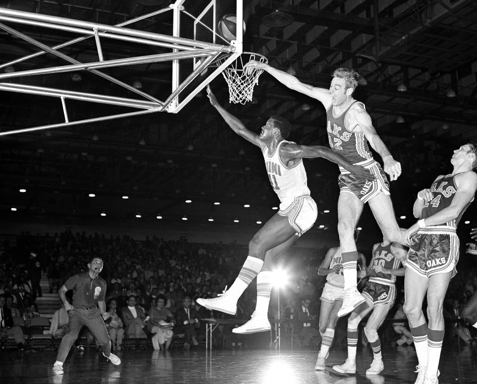 FILE - Miami Floridians' Les Hunter (41) is fouled by Oakland Oaks' Jim Eakins (42) while scoring a basket during an ABA basketball game in Miami, Nov. 28, 1968. The ABA developed some true stars of the game, including Calvin, Julius Erving, Artis Gilmore and George Gervin, but it's largely remembered for paltry crowds, shaky finances and a red, white and blue ball. (AP Photo/Toby Massey, File)