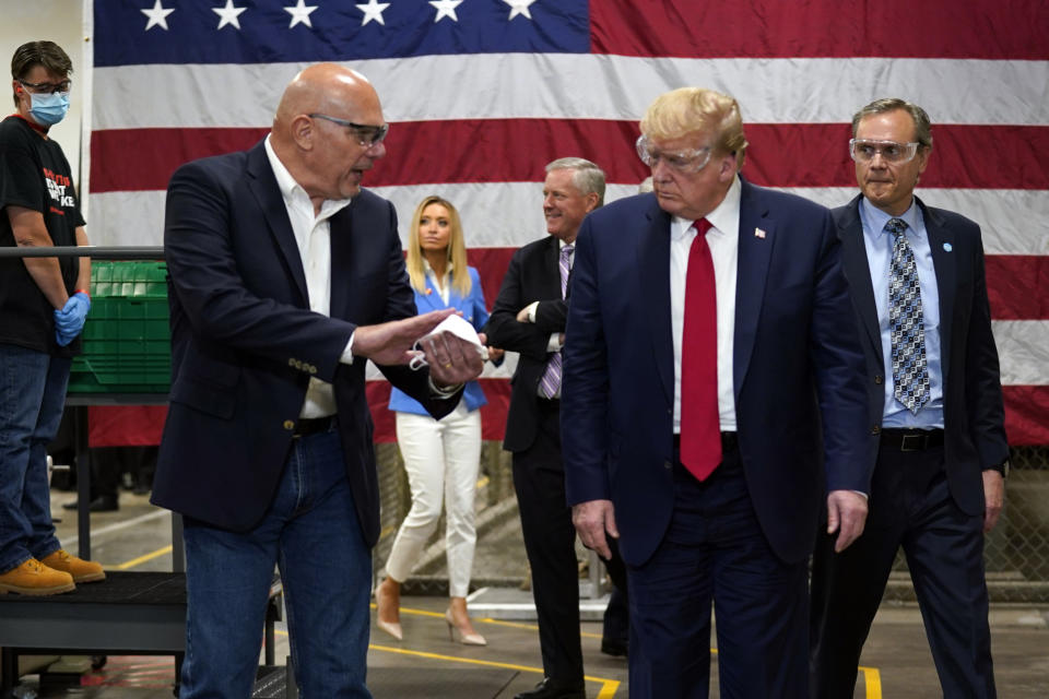 President Donald Trump participates in a tour of a Honeywell International plant that manufactures personal protective equipment, Tuesday, May 5, 2020, in Phoenix, with Tony Stallings, vice president of Integrated Supply Chain at Honeywell. (AP Photo/Evan Vucci)