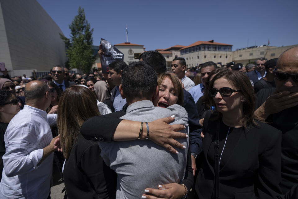 Palestinian friends and colleagues of slain Al Jazeera journalist Shireen Abu Akleh, who was shot dead Wednesday during an Israeli military raid in the West Bank city of Jenin, cry and comfort each other during an official ceremony at the Palestinian Authority headquarters in Ramallah Thursday, May 12, 2022. Thousands gathered to mourn Abu Akleh in the occupied West Bank city of Ramallah on Thursday, as the head of the Palestinian Authority blamed Israel for her death and rejected Israeli calls for a joint investigation. (AP Photo/Nasser Nasser)