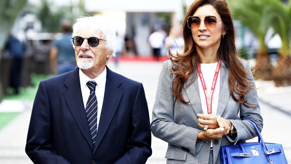 Bernie Ecclestone and his wife Fabiana walk before the F1.