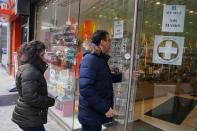 People walk into a pharmacy to buy N95 masks in advance of the potential coronavirus outbreak, in the Manhattan borough of New York City