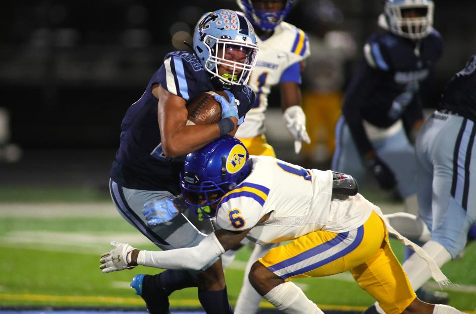 Central Valley's Landon Alexander (23) gets wrapped up for a tackle by East Allegheny's Prashuan Gainer (6) during the first half of the WPIAL 3A quarterfinals game at Central Valley High School.