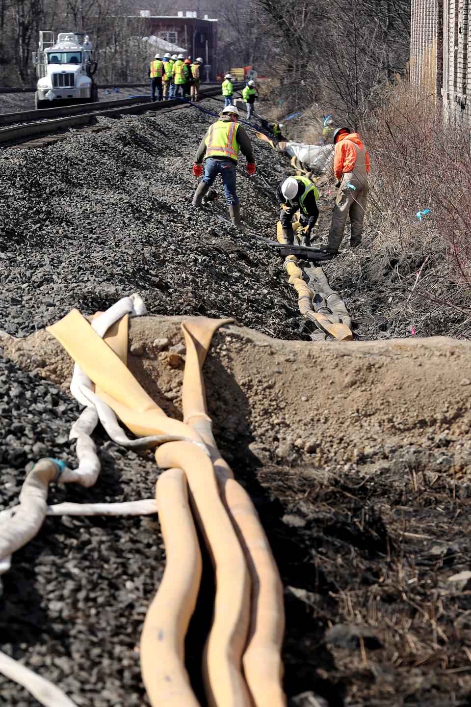 Crews clean out and take samples of soil and water from the ditches near the site of the Norfolk Southern train derailment, Tuesday, Feb. 21, 2023, in East Palestine, Ohio.
