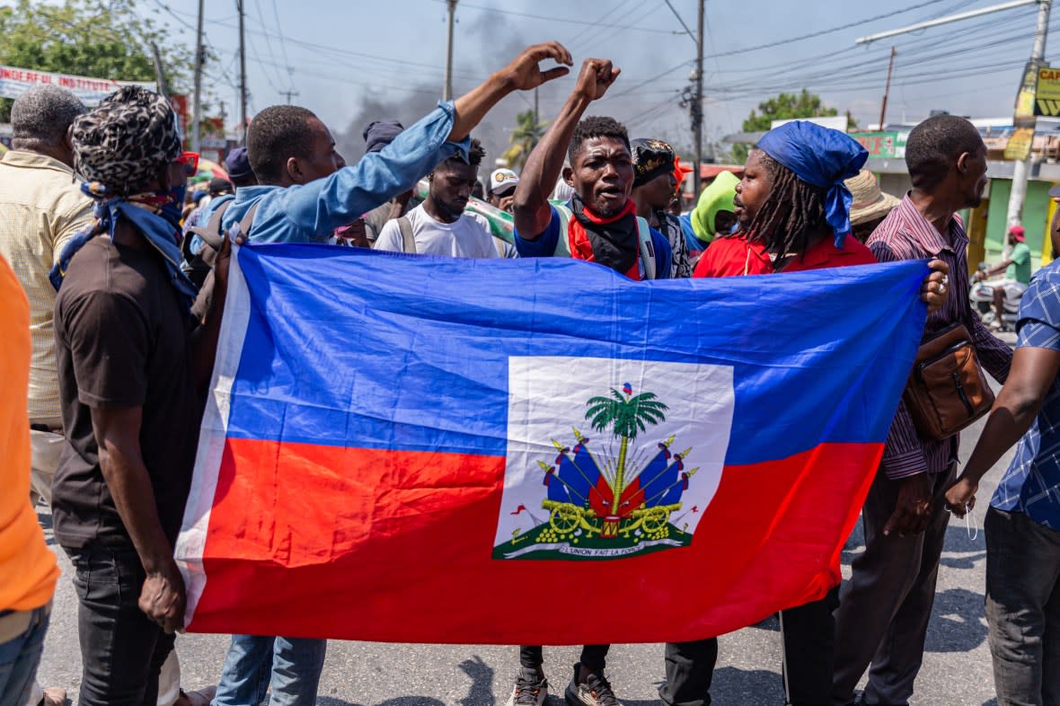 People react with a Haitian flag in their hand during a demonstration against CARICOM for the decision following the resignation of Haitian Prime Minister Ariel Henry as representatives of the Caribbean Community (CARICOM) and Haitian actors made an agreement for political transition in Haiti it a historic decision that was made by the formation of a seven-member Presidential Council (CP), and the Haitian government on Tuesday extended the night-time curfew and state of emergency in the capital of Port-au-Prince for a month amid a wave of violence triggered by armed groups in Port-au-Prince, Haiti, on March 12, 2024. (Photo by Guerinault Louis/Anadolu via Getty Images)