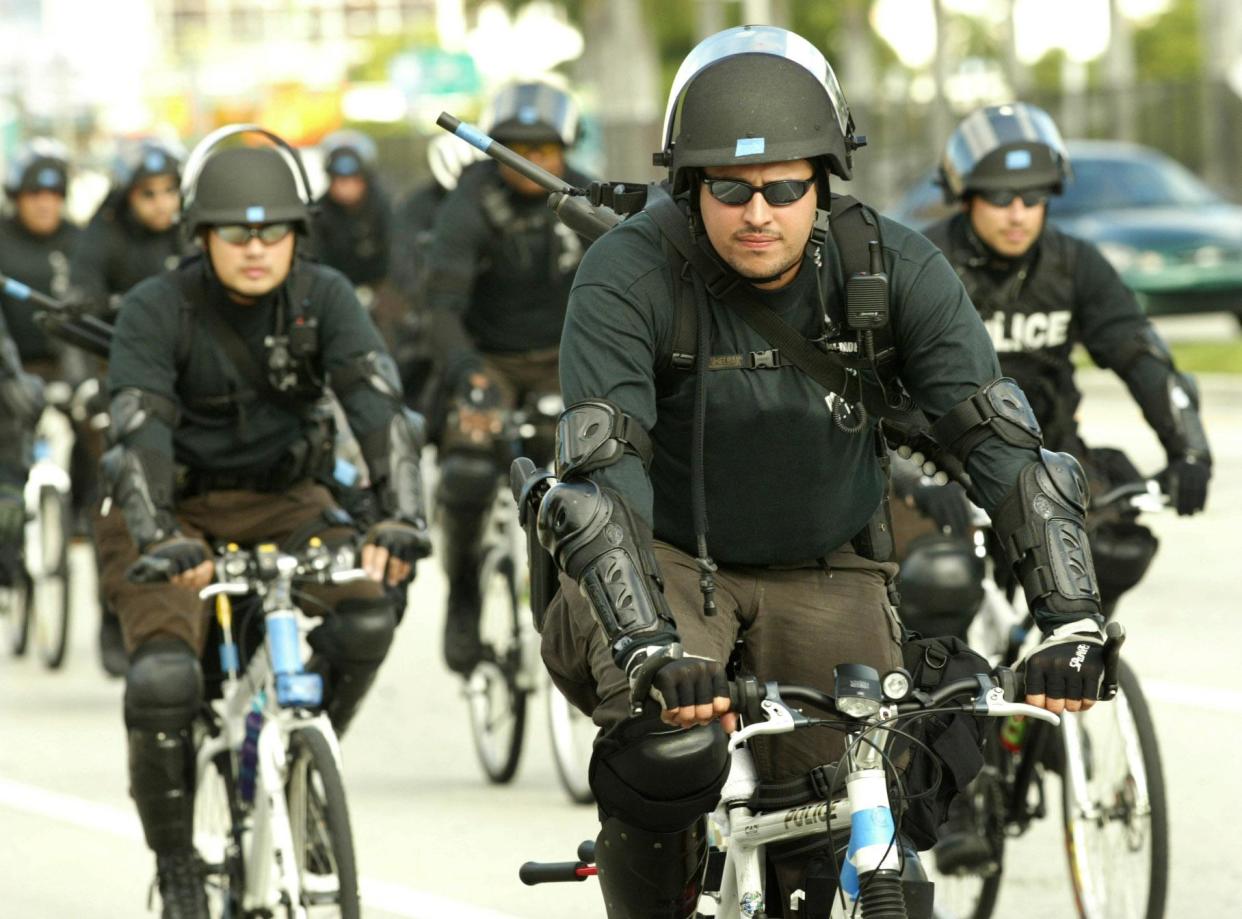 Riot police ride bicycles on Biscayne Boulevard in Florida: REUTERS
