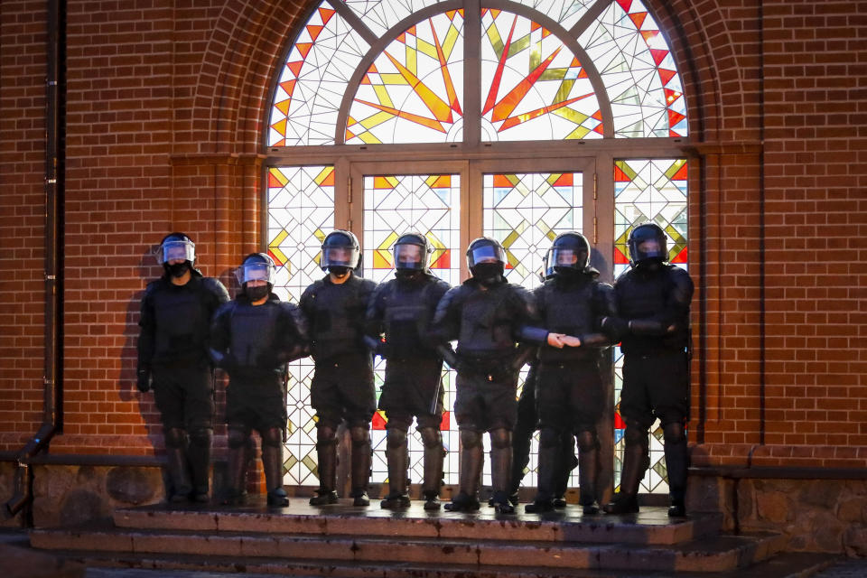 FILE - Riot police block an entrance of Sts. Simon and Helena Catholic Church, also known as the “Red Church” for the color of its bricks, during an anti-government protest in Independence Square in Minsk, Belarus, on Wednesday, Aug. 26, 2020. (AP Photo, File)