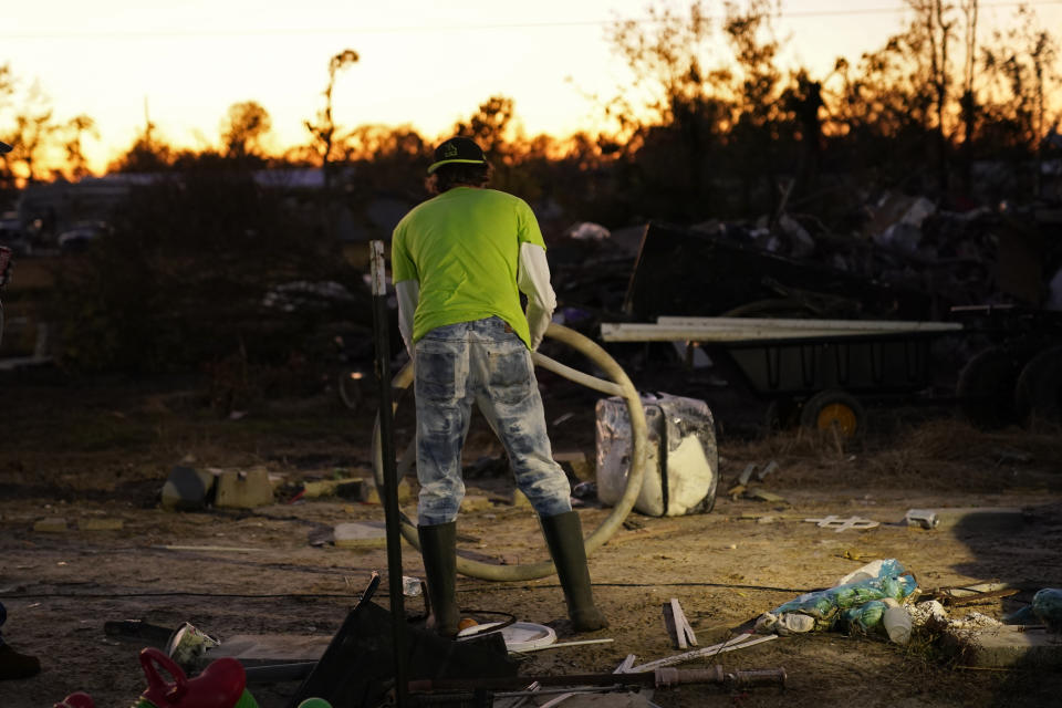 Ricky Trahan sorts debris from his destroyed home, where he now lives in a tent with his wife, in the aftermath of Hurricane Laura and Hurricane Delta, in Lake Charles, La., Friday, Dec. 4, 2020. (AP Photo/Gerald Herbert)