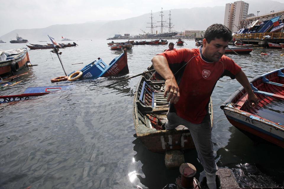 Un pescador salta de un bote en el puerto de Iquique, Chile, el miércoles 2 de abril de 2014. La suspensión el miércoles de la alerta de tsunami que afectó las costas chilenas tras el terremoto de magnitud 8,2 ocurrido en el extremo norte del país, permitió el lento regreso a sus hogares de decenas de miles de personas que amanecieron al aire libre.(AP foto/ Luis Hidalgo, Pool)