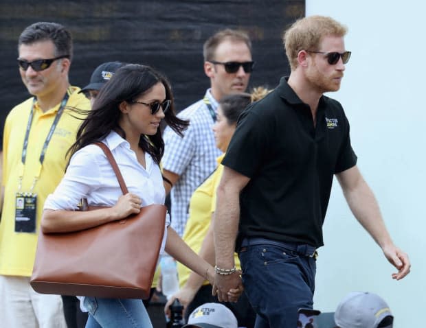<p>Meghan and Harry subsequently made their first official appearance in public as a couple at a wheelchair tennis match during the Invictus Games. Meghan's famous white "Husband Shirt" was again by her close friend Misha Nonoo, which she paired with skinny jeans and the biggest leather tote bag we ever did see.</p>