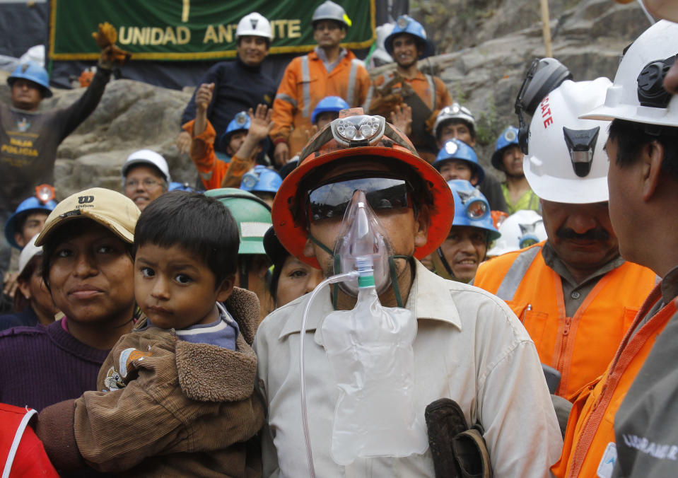 ** CORRECTS TO REMOVE EXTRANEOUS LAST SENTENCE ** Miner Jacinto Pariona, center right, stands with his family after he was the first miner to be rescued from the Cabeza de Negro gold-and-copper mine in Yauca del Rosario, Peru, Wednesday April 11, 2012.  Nine miners had been trapped inside a wildcat mine since April 5.  (AP Photo/Martin Mejia)