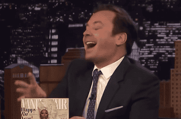 Jimmy Fallon laughing while holding a "Vanity Fair" magazine on his talk show