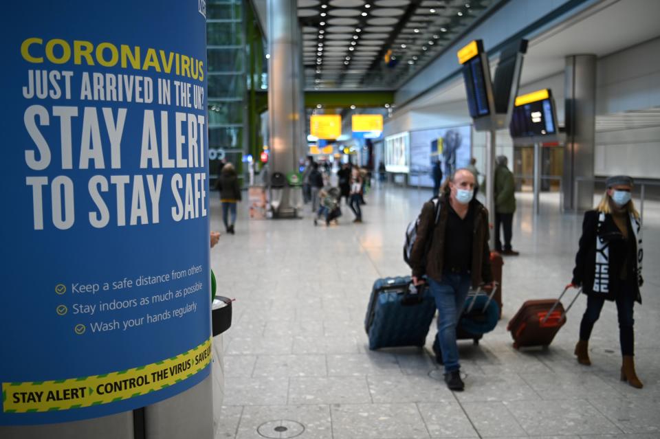 Coronavirus health warnings are seen in the arrivals hall after at London Heathrow Airport in west London, on January 15, 2021. - International travellers will need to present proof of a negative coronavirus test result in order to be allowed into England, or face a £500 ($685, 564 euros) fine on arrival, from January 18. (Photo by DANIEL LEAL-OLIVAS / AFP) (Photo by DANIEL LEAL-OLIVAS/AFP via Getty Images)