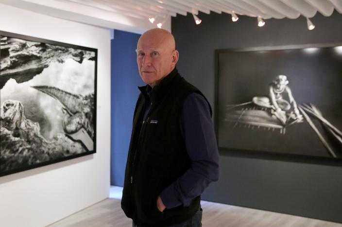 Sebastiao Salgado looks at images in his "Genesis" exhibition on December 13, 2014 at a gallery in Hong Kong (AFP Photo/Isaac Lawrence)