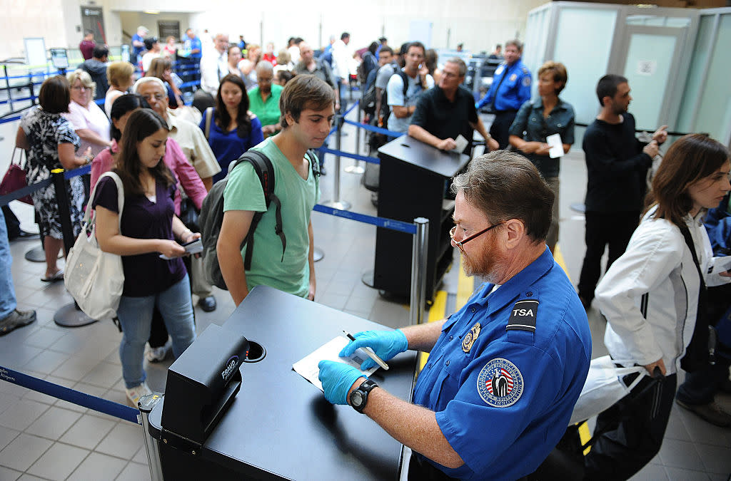 A TSA agent checks an ID under a Fraud Fighter machine at LAX. (Wally Skalij/Los Angeles Times)