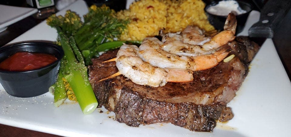 Blackened prime rib and grilled shrimp with a side of grilled asparagus and saffron rice from C-Level Bar and Grill.