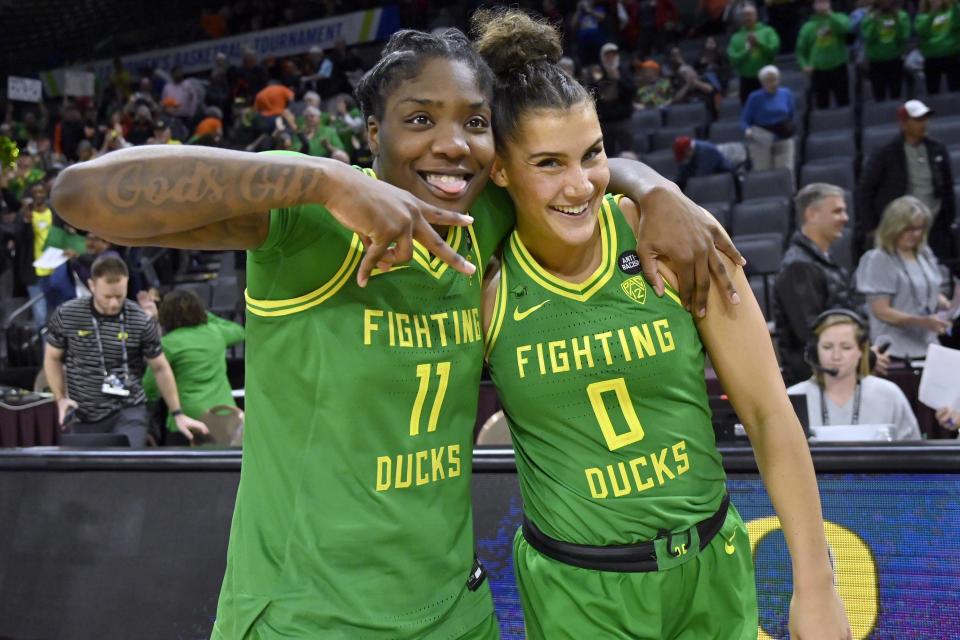 Oregon forward Taylor Hosendove (11) and guard Taya Hanson (0) celebrate the team's victory over Washington after an NCAA college basketball game in the first round of the Pac-12 women's tournament Wednesday, March 1, 2023, in Las Vegas. (AP Photo/David Becker)