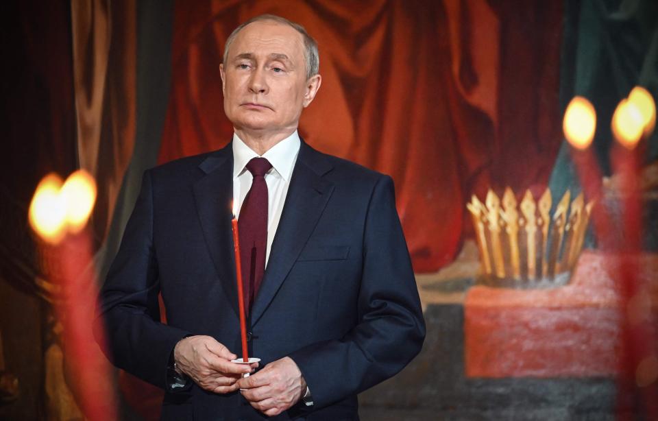 Russian President Vladimir Putin holds a candle during an Orthodox Easter service, late on April 23, 2022, in Moscow.