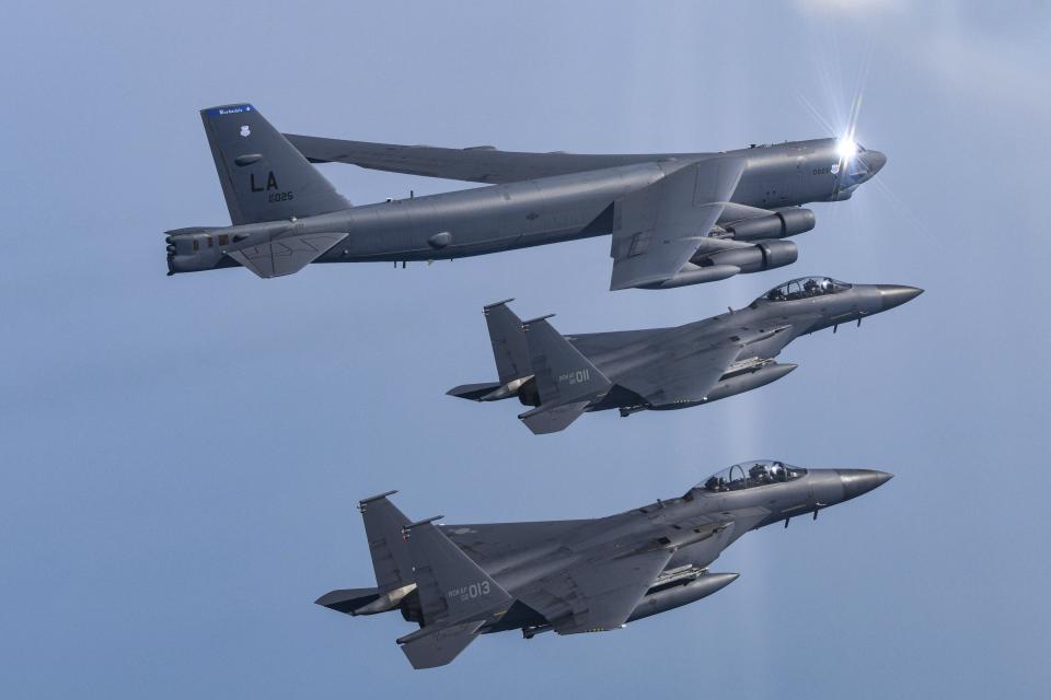 In this photo provided by South Korea Defense Ministry, a U.S. Air Force B-52H Stratofortress aircraft, top, flies in formation with South Korea's Air Force F-15K fighters over the western sea of Korean peninsula during a joint air drill in South Korea, Monday, March 6, 2023.(South Korea Defense Ministry via AP)
