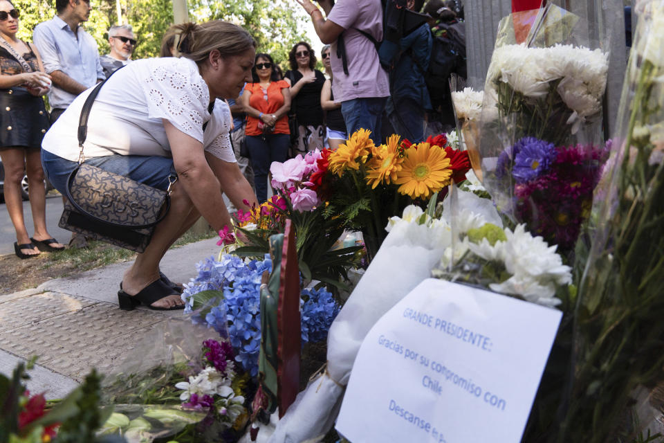 Personas dejan flores en la casa del fallecido expresidente chileno Santiago Piñera en Santiago, Chile, tras darse a conocer la noticia de su fallecimiento en un accidente de helicóptero el martes 6 de febrero de 2024. (AP Foto/Matías Basualdo)