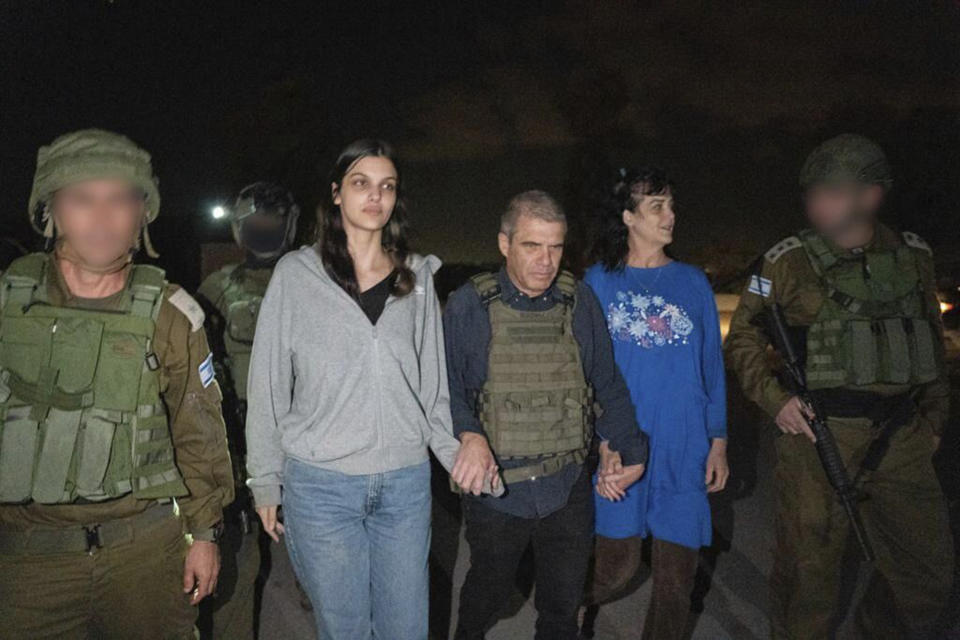 En esta fotografía proporcionada por el gobierno de Israel, Judith Raanan (derecha) y su hija de 17 años de edad, Natalie, son escoltadas por soldados israelíes y Gal Hirsch, el coordinador especial del primer ministro Benjamin Netanyahu para regresar a rehenes a Israel, mientras vuelven a Israel el viernes 20 de octubre de 2023 luego de que Hamas las capturó. (Gobierno de Israel vía AP Foto)