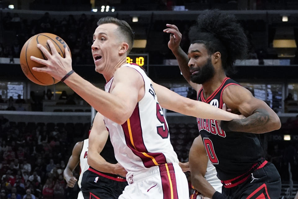 Miami Heat forward Duncan Robinson, left, drives to the basket past Chicago Bulls guard Coby White, right, during the first half of an NBA basketball game in Chicago, Saturday, Nov. 18, 2023. (AP Photo/Nam Y. Huh)