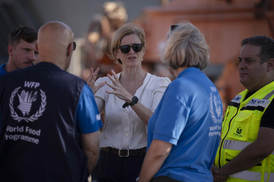U.S. Agency for International Development Administrator Samantha Power, center, talks to World Food Program (WFP) members as they visit the port where cargo ships arrive, carrying humanitarian aid for Gaza Strip, in Ashdod, Israel, Thursday, July 11, 2024. (AP Photo/Leo Correa)
