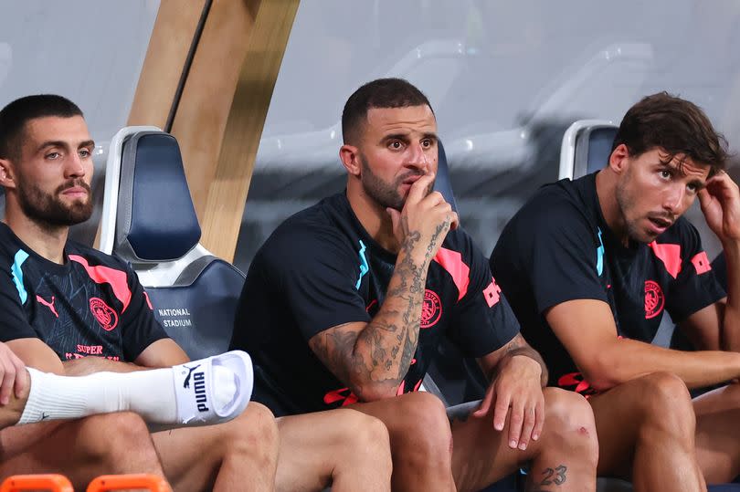 Kyle Walker sits on the bench with Mateo Kovacic and Ruben Dias either side of him during last summer's pre-season trip to Japan.