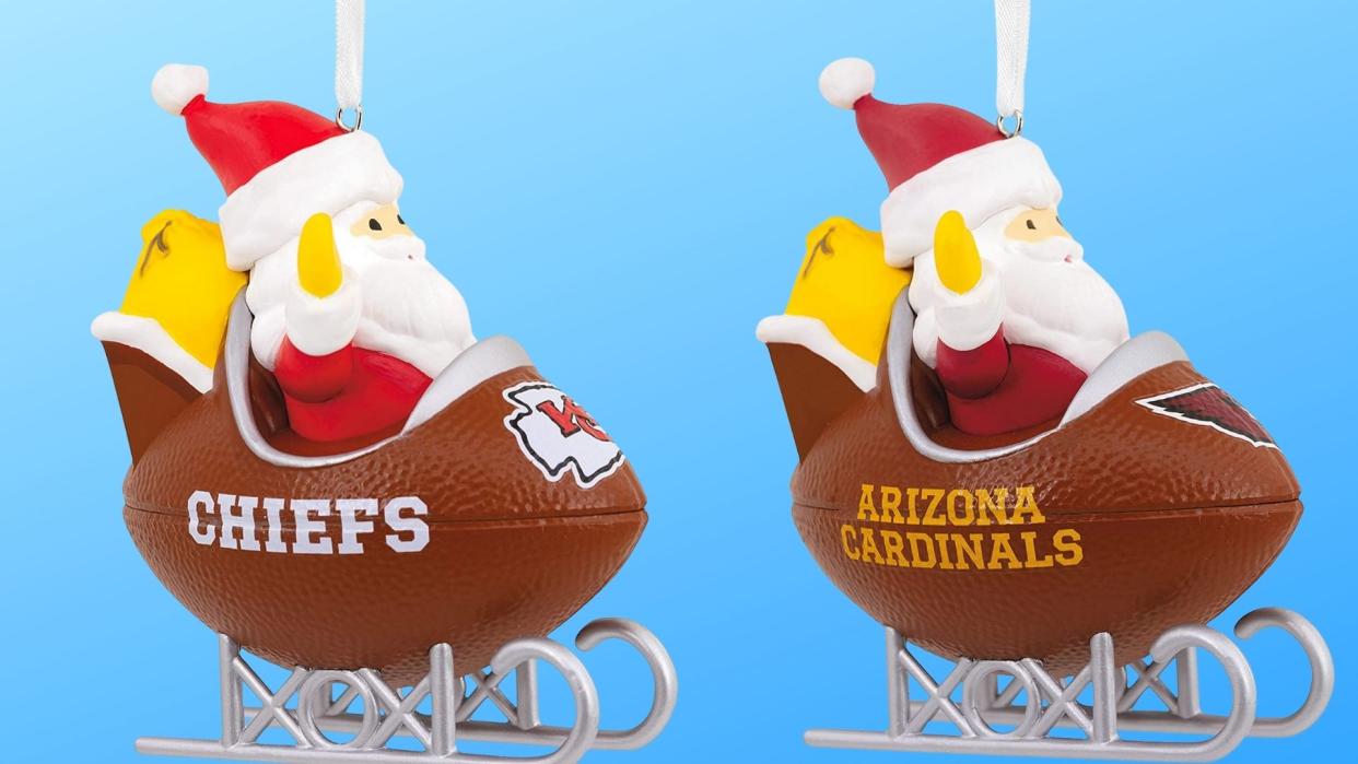 2 Santas in football sled with Chiefs and Cardinals logo in front.