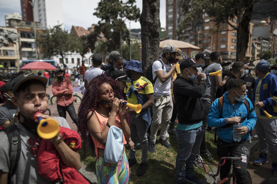 Protesters march toward the residence of Bogota Mayor Claudia López to demand the lifting of the city-wide curfew and the reopening of business amid the COVID-19 pandemic in Bogota, Colombia, Wednesday, Jan. 20, 2021. (AP Photo/Ivan Valencia)