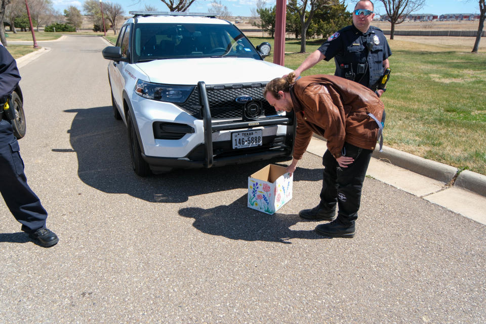 A student drops off a box of letters to the WT president's residence Friday afternoon in Canyon.