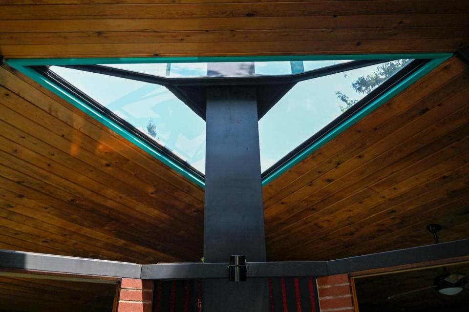 The three-sided fireplace is vented in the center of the home and surrounded by a triangular skylight.