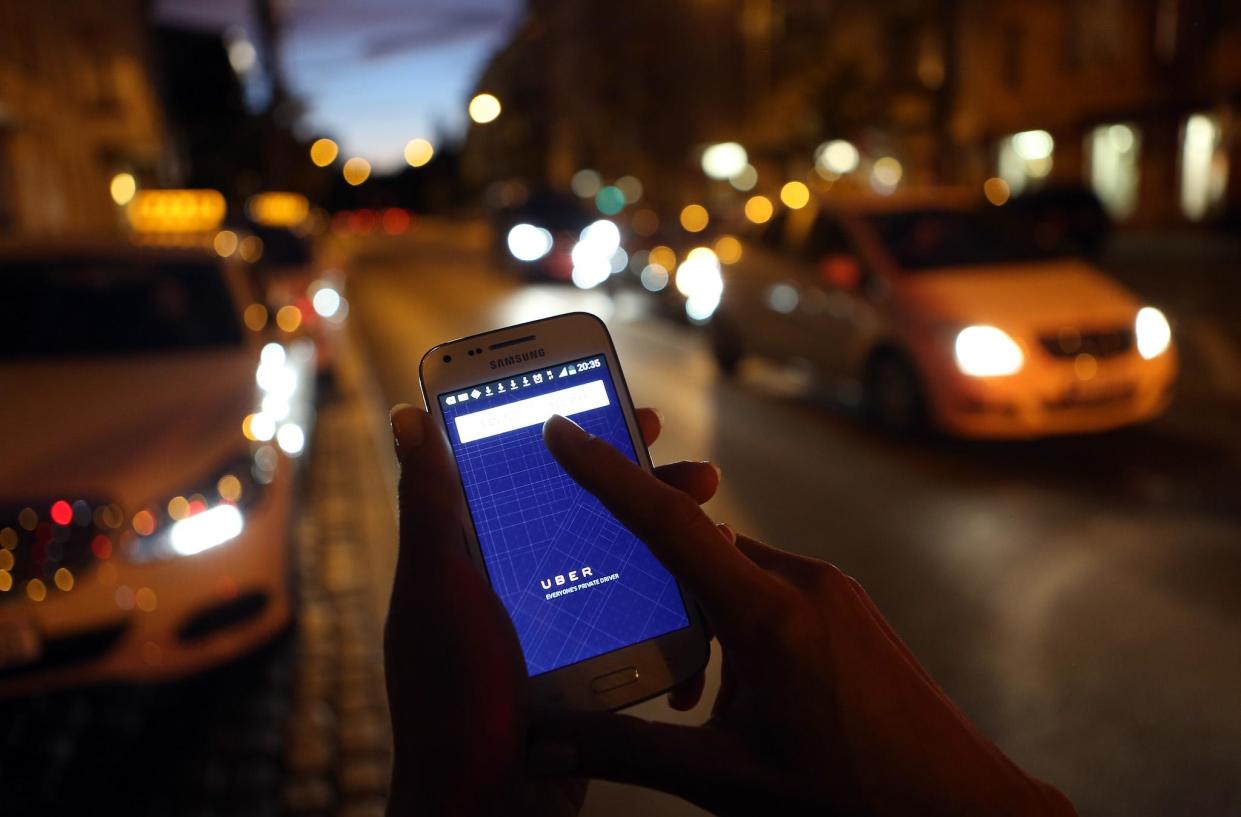 In this photo illustration, a woman uses the Uber app on an Samsung smartphone on September 2, 2014 in Berlin, Germany: Adam Berry/Getty Images