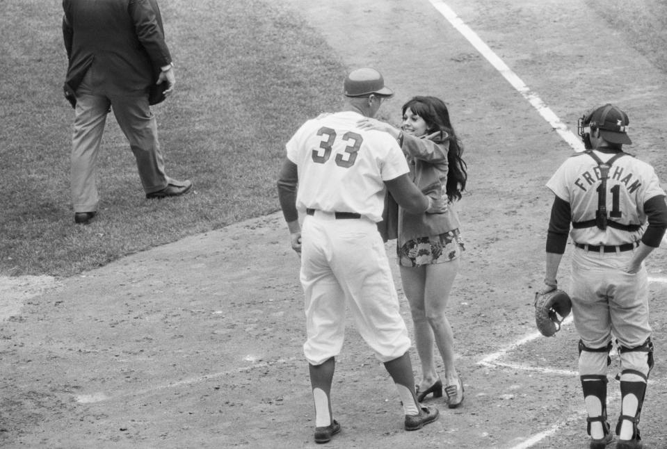 This mini-skirted fan jumped down from the stands and ran up to home plate with a big kiss for Frank Howard when Washington slugger came to bat in the first inning of the season's opener here.