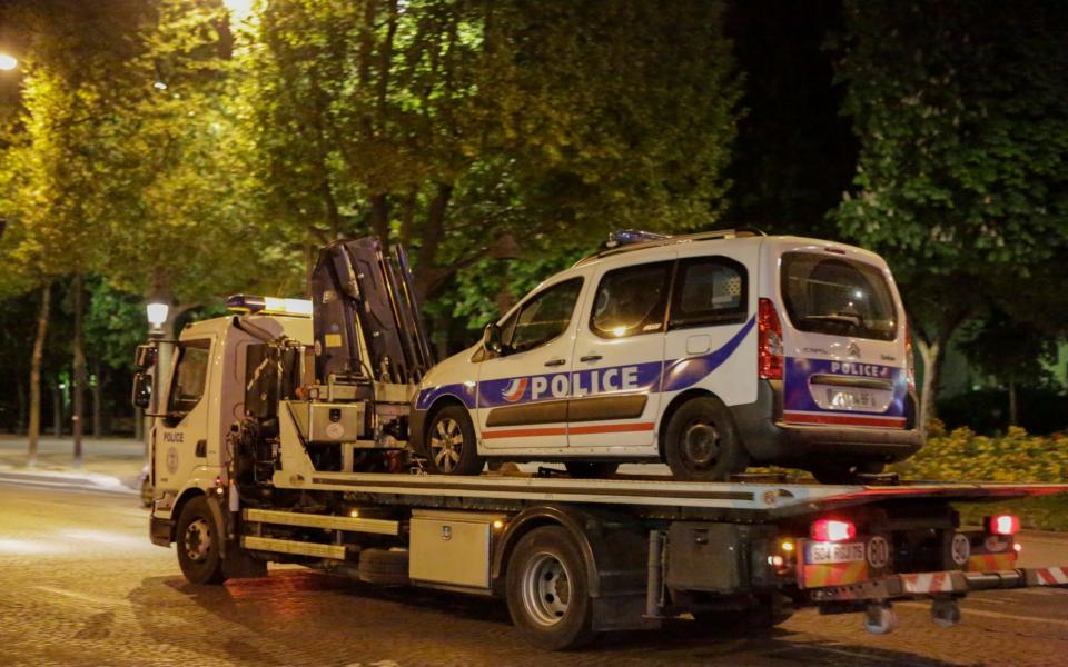 A police van is towed away from the Champs-Elysees following the shooting - Credit: Barcroft