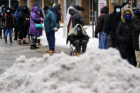 People wait in line for the opening of a 24-hour, walk-up COVID-19 vaccination clinic hosted by the Black Doctors COVID-19 Consortium at Temple University's Liacouras Center in Philadelphia. States are working quickly get the coronavirus vaccine into people’s arms after last week’s icy storms, freezing temperatures and widespread power outages closed clinics and slowed vaccine deliveries nationwide. (AP Photo/Matt Rourke, File)